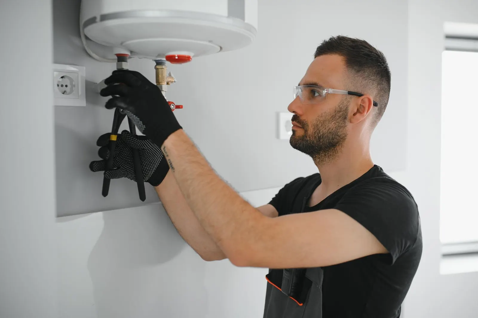 Plombier professionnel vérifiant une chaudière et ses tuyaux
